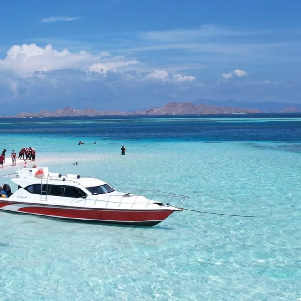 Turis menikmati perjalanan dengan speedboat di Taman Nasional Komodo.