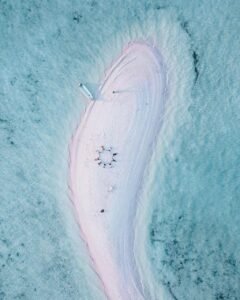 Wisatawan snorkeling di laut jernih Pantai Pink selama paket liburan akhir tahun di Labuan Bajo