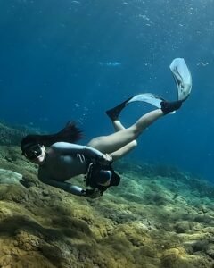 Snorkeling di Pulau Komodo dengan air laut jernih dan panorama bawah laut yang memukau.