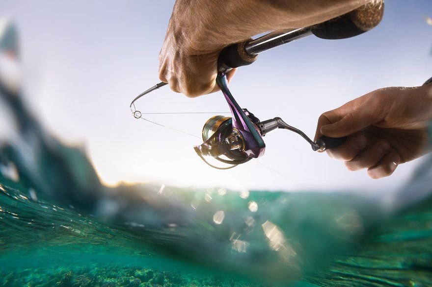 Image of an individual fishing from a small boat or riverbank under a clear sky showing the stillness of the water