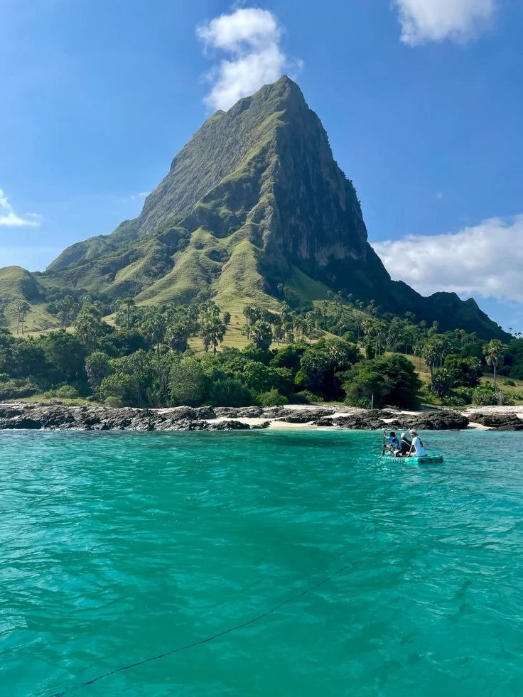 Scenic beach view of Mules Island with clear turquoise water and lush green hills