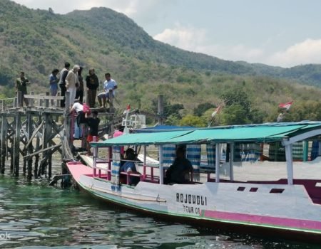 Traditional wooden boat sailing to Rangko Cave in Flores, Indonesia