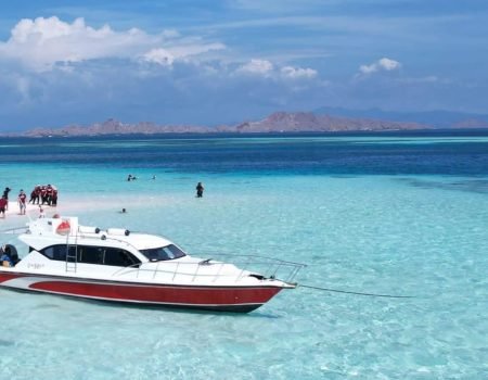 Turis menikmati perjalanan dengan speedboat di Taman Nasional Komodo.