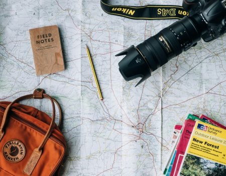 flat lay photography of camera, book, and bag
